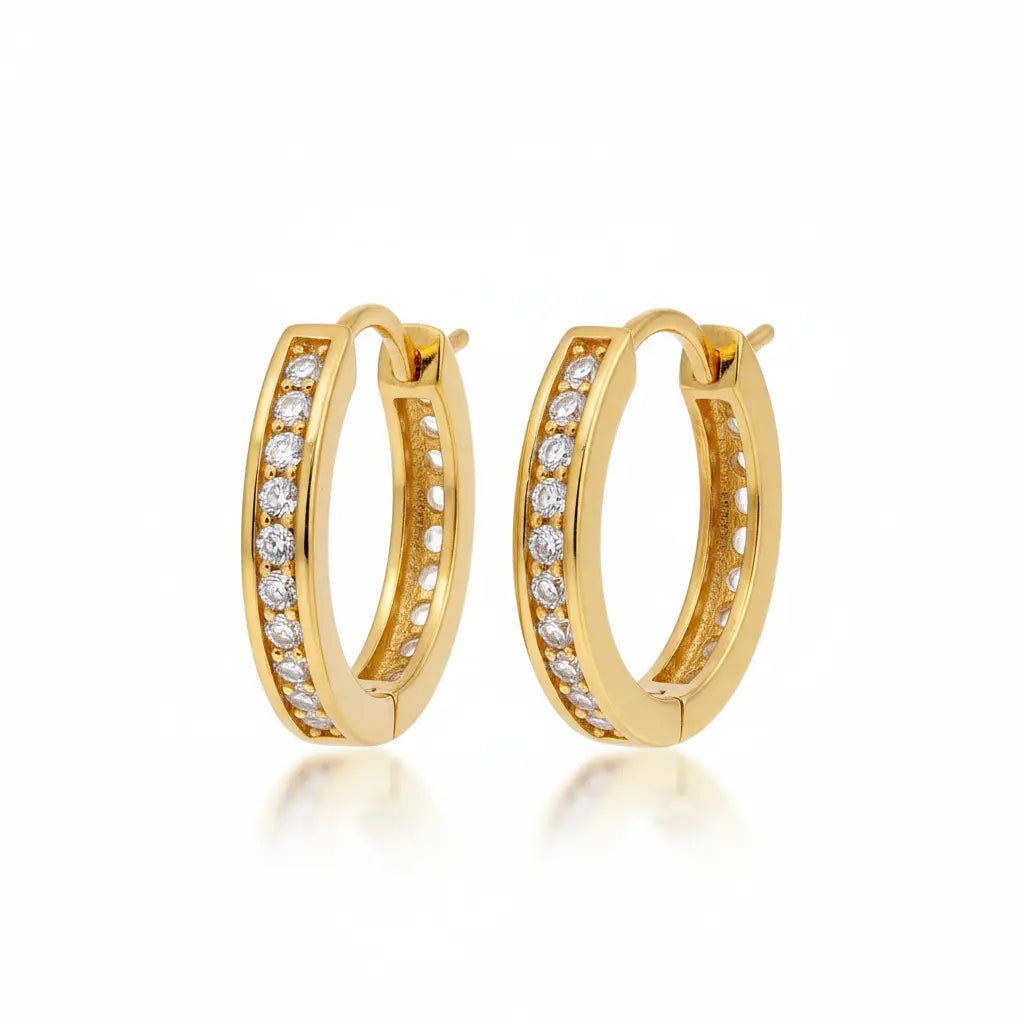 A pair of gold hoop earrings with rows of clear pavé-set stones, shown on a clean white background with a soft reflection below.