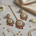 Ornate jewelry set with earrings and necklace on a marble surface