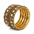 Gold bangles with colorful gemstones on a white background