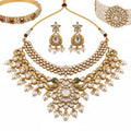 Gold necklace with pearls and gemstones on a white background