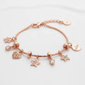 A rose gold charm bracelet featuring a beaded chain with dangling star, heart, and round charm elements, including a clear crystal and a round engraved tag that reads 'SKY&STAR'.